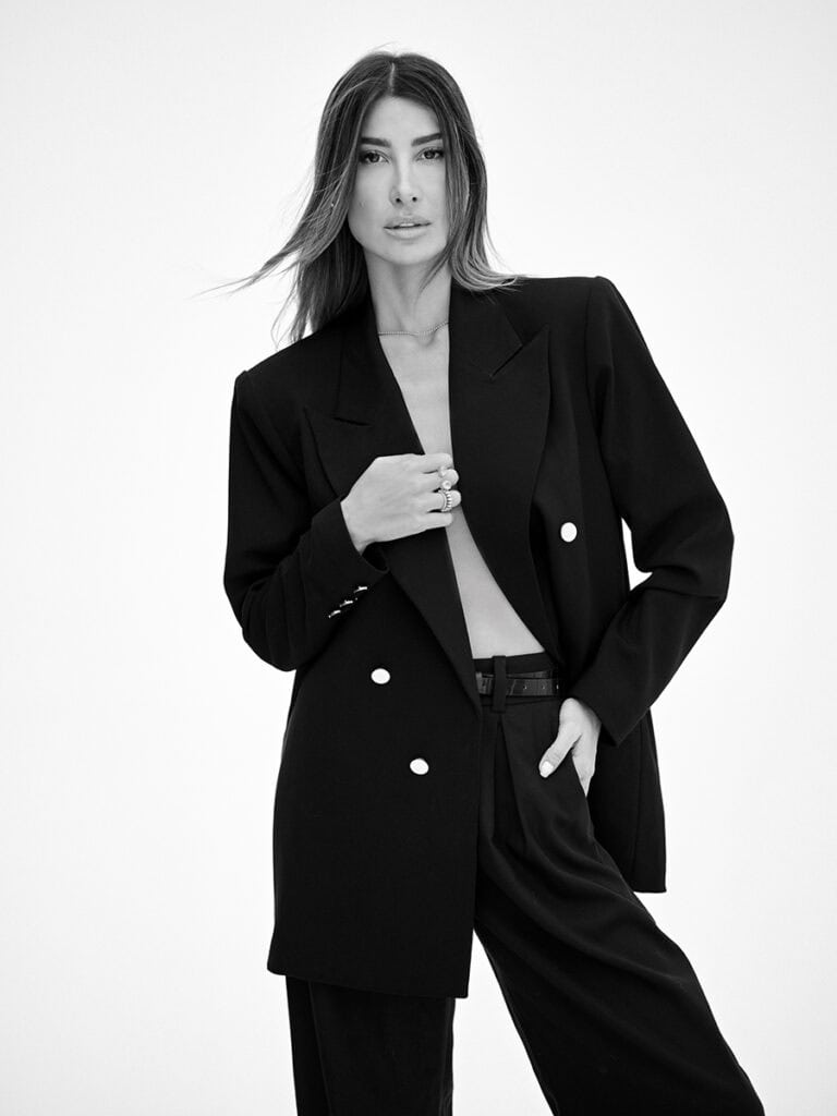 Elegante mulher usando blazer preto, look fashionista, fotografia em preto e branco, moda feminina, estilo profissional.